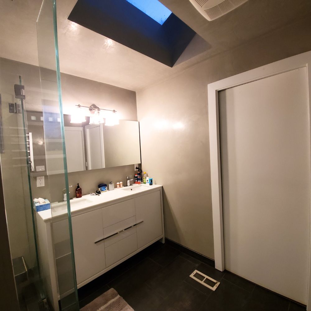 Fluorescent lighting above the mirror adding warmth to the bathroom